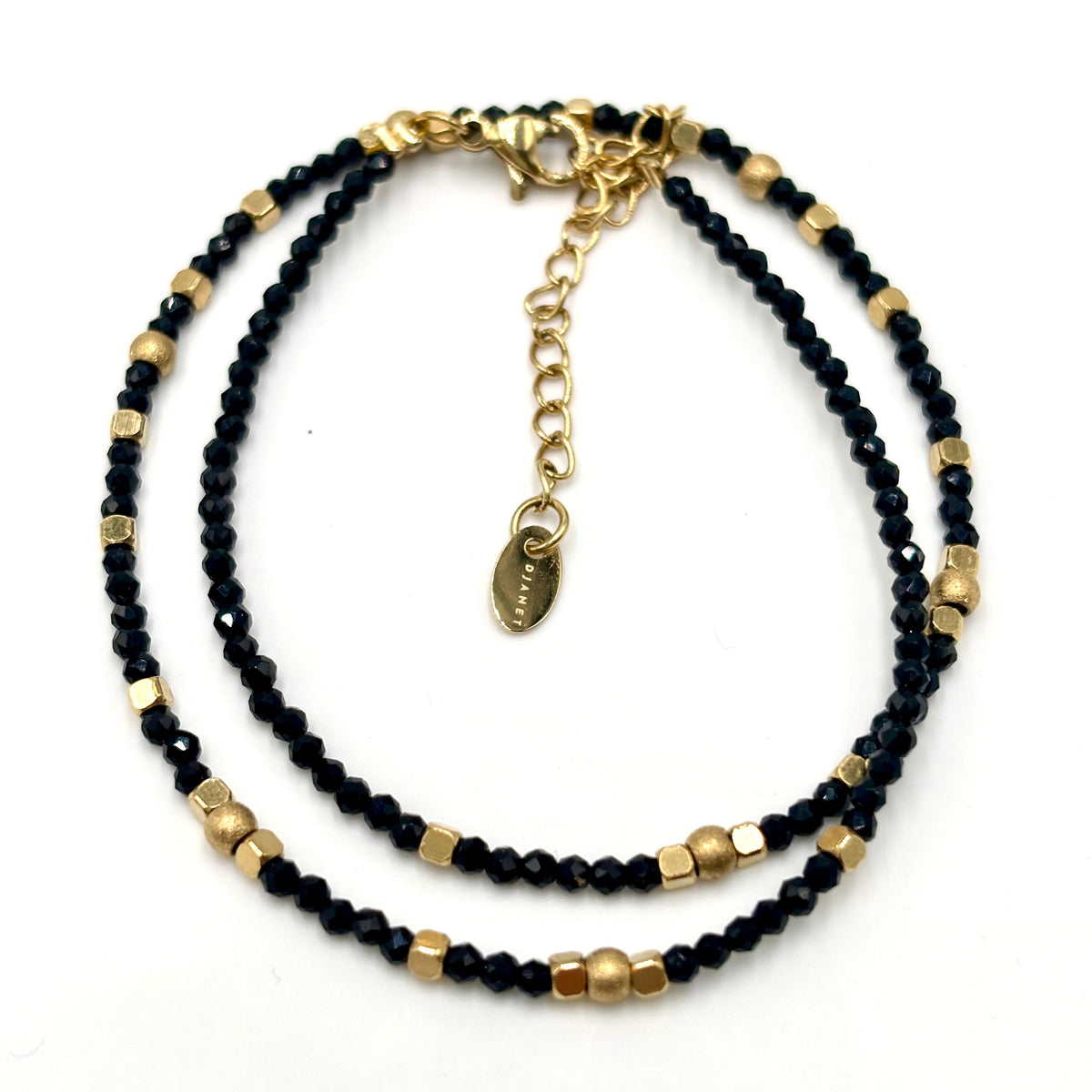 Bracelet double tour en petites perles noires et éléments dorés, avec fermoir et rallonge
