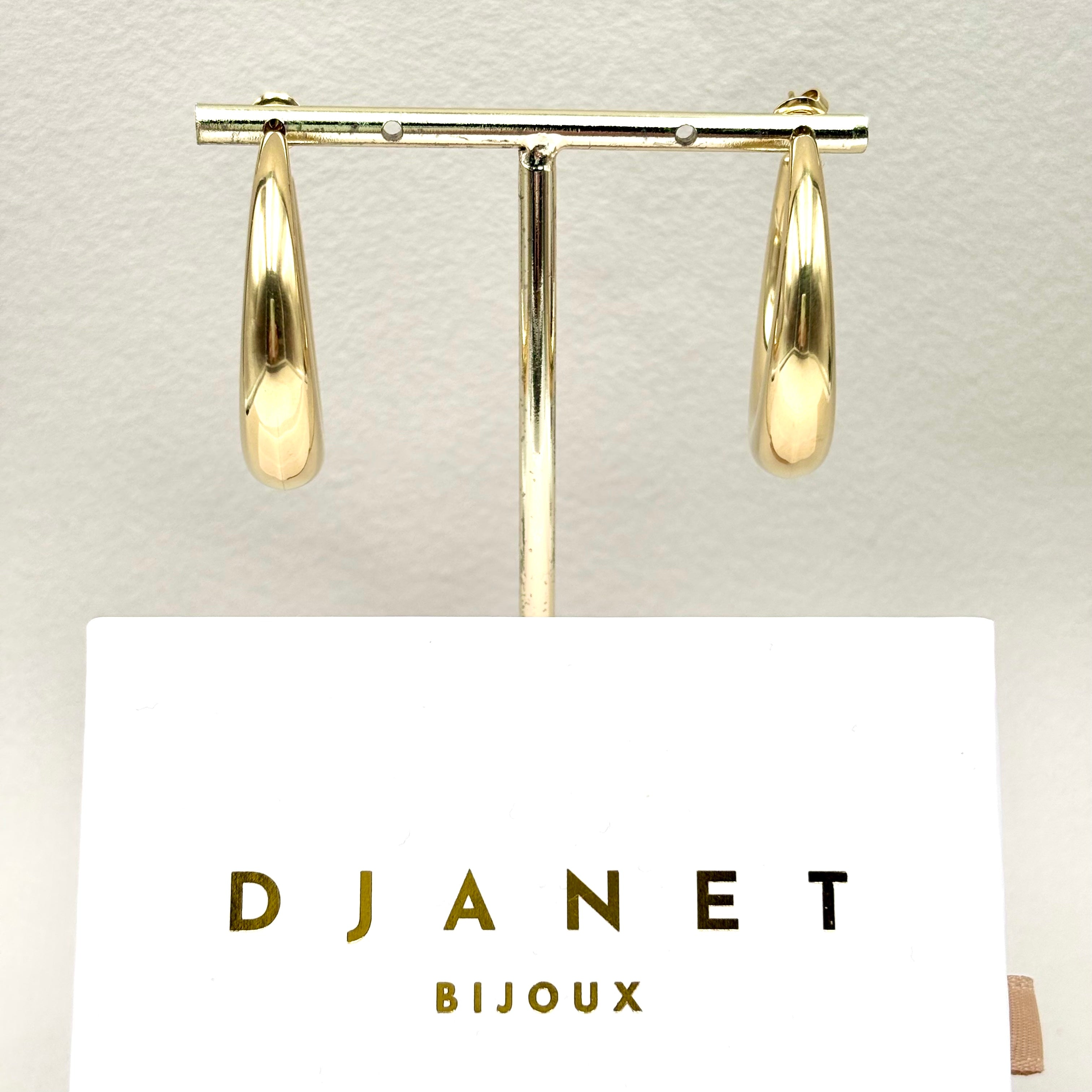 Boucles d'oreilles créoles ouvertes en acier doré sur présentoir en acier doré et boite cadeau