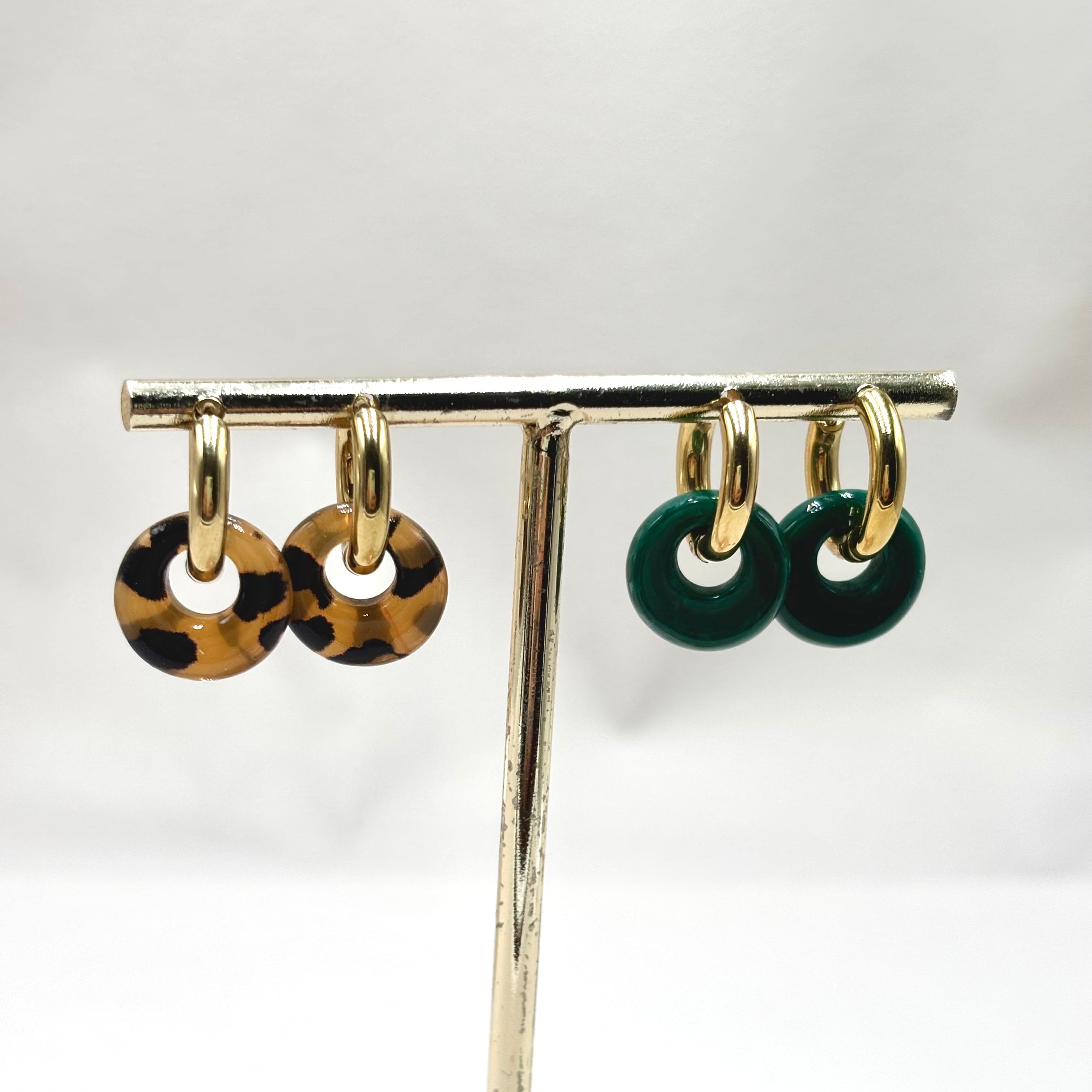 Boucles d'oreilles mini créoles en acier inoxydable doré en acétate coloré leopard et vert sur présentoir