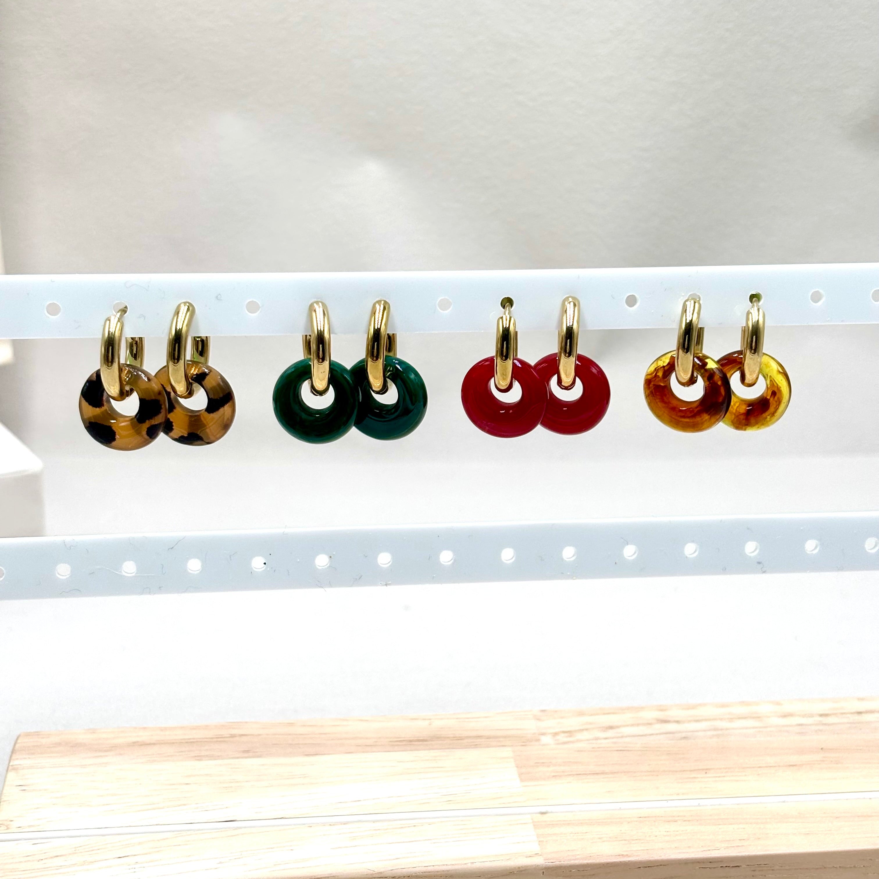 Boucles d'oreilles mini créoles en acier inoxydable doré en acétate coloré sur présentoir