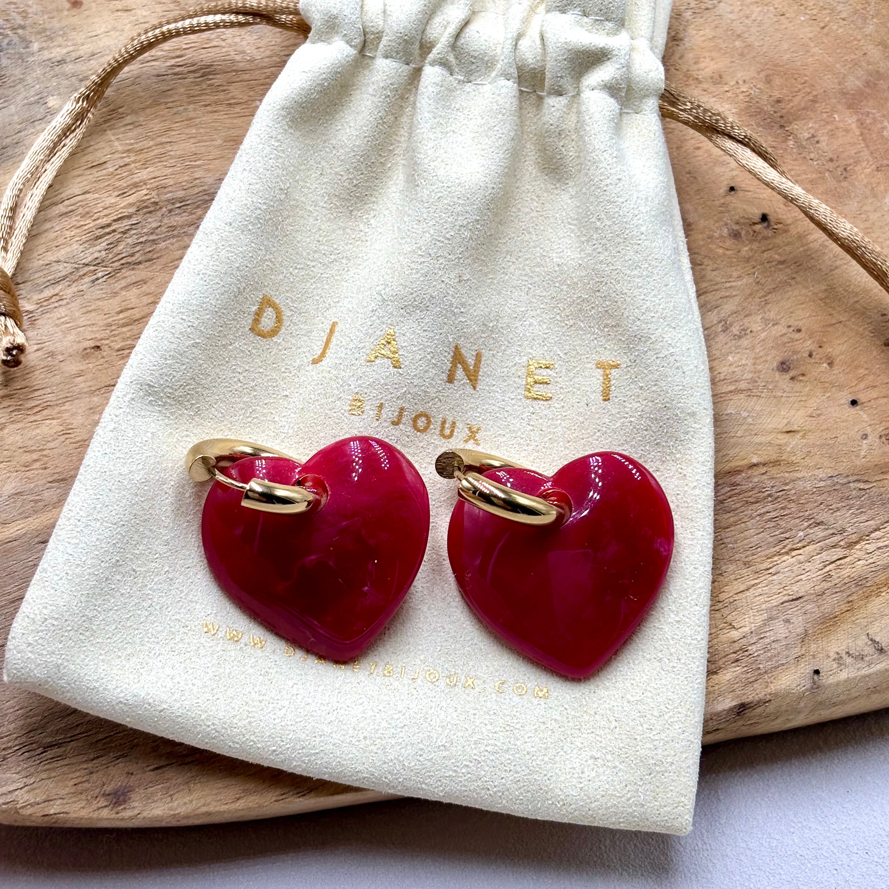 Boucles d'oreilles créoles en acier doré et coeur rouge en acetate sur pochon Djanet Bijoux