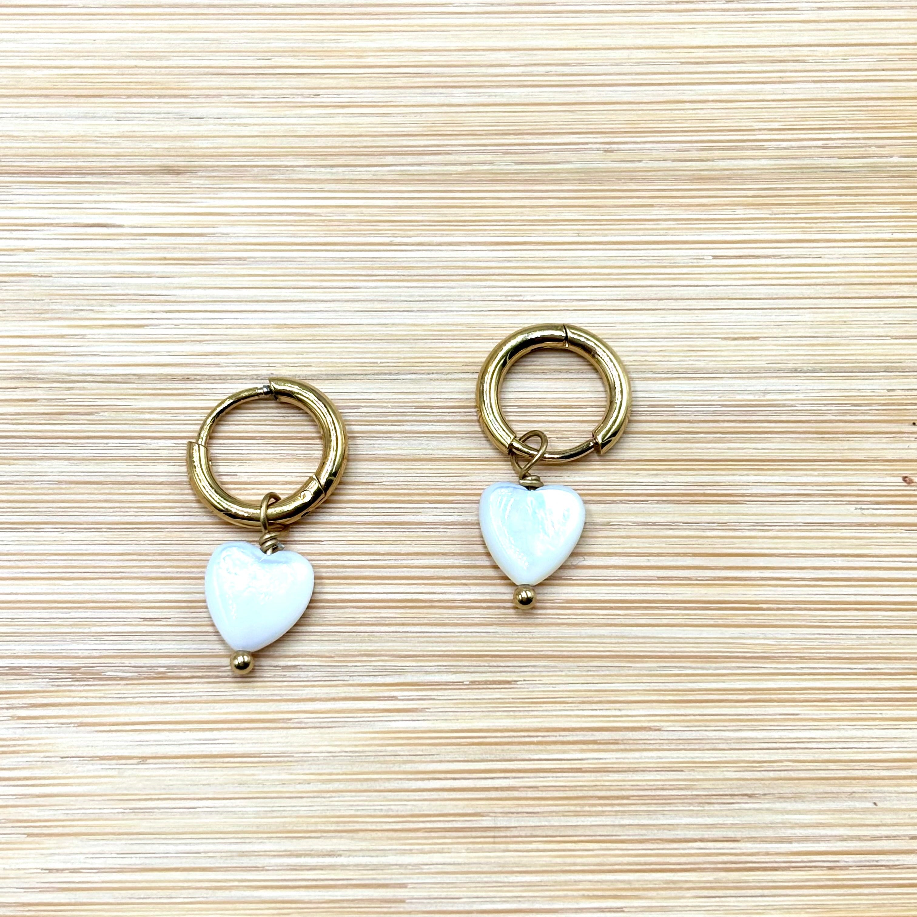 Boucles d'oreilles mini créoles en acier inoxydable doré et coeur nacré fond bois Djanet Bijoux