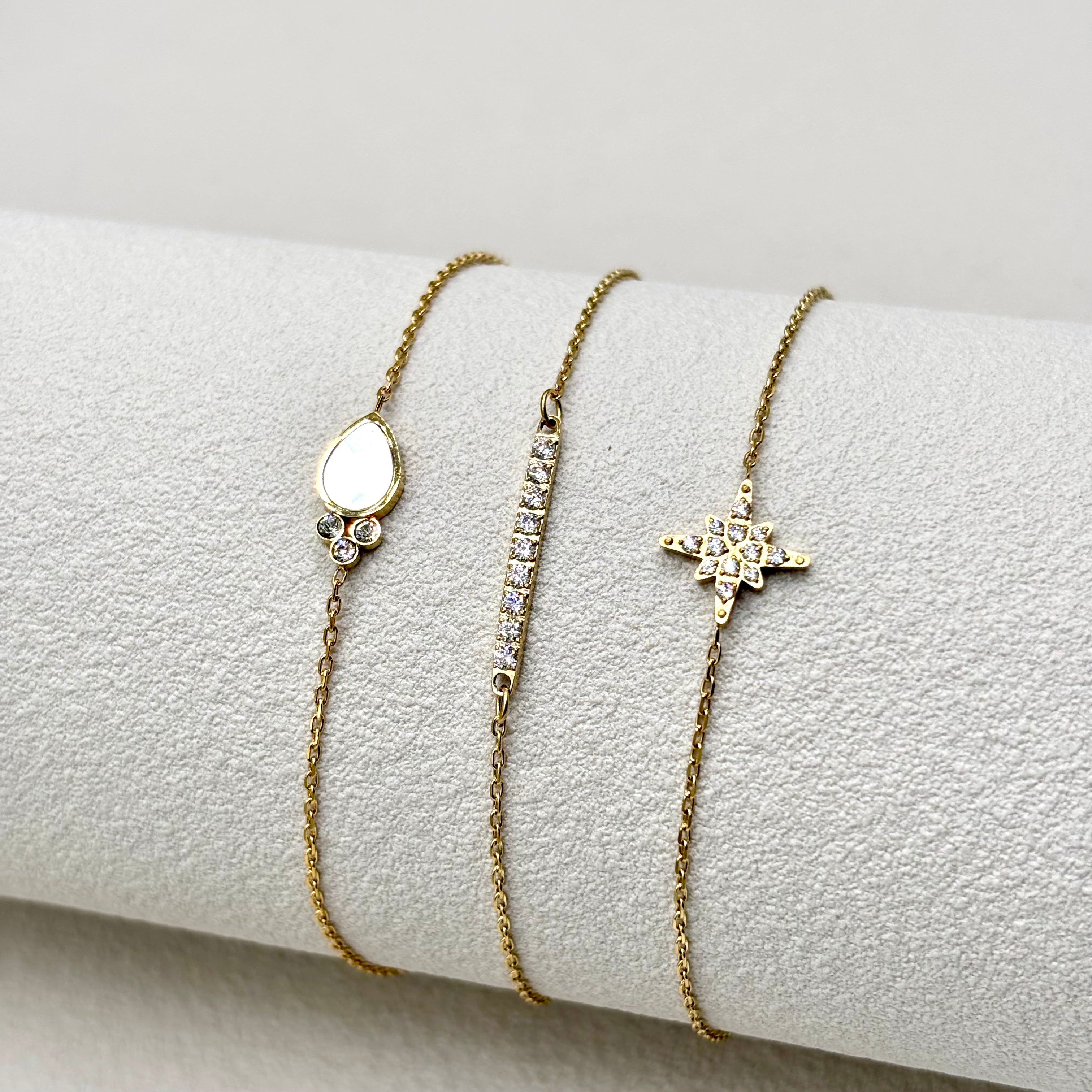 Trio de bracelets fins acier inoxydable doré et oxydes de zirconium sur présentoir rouleau