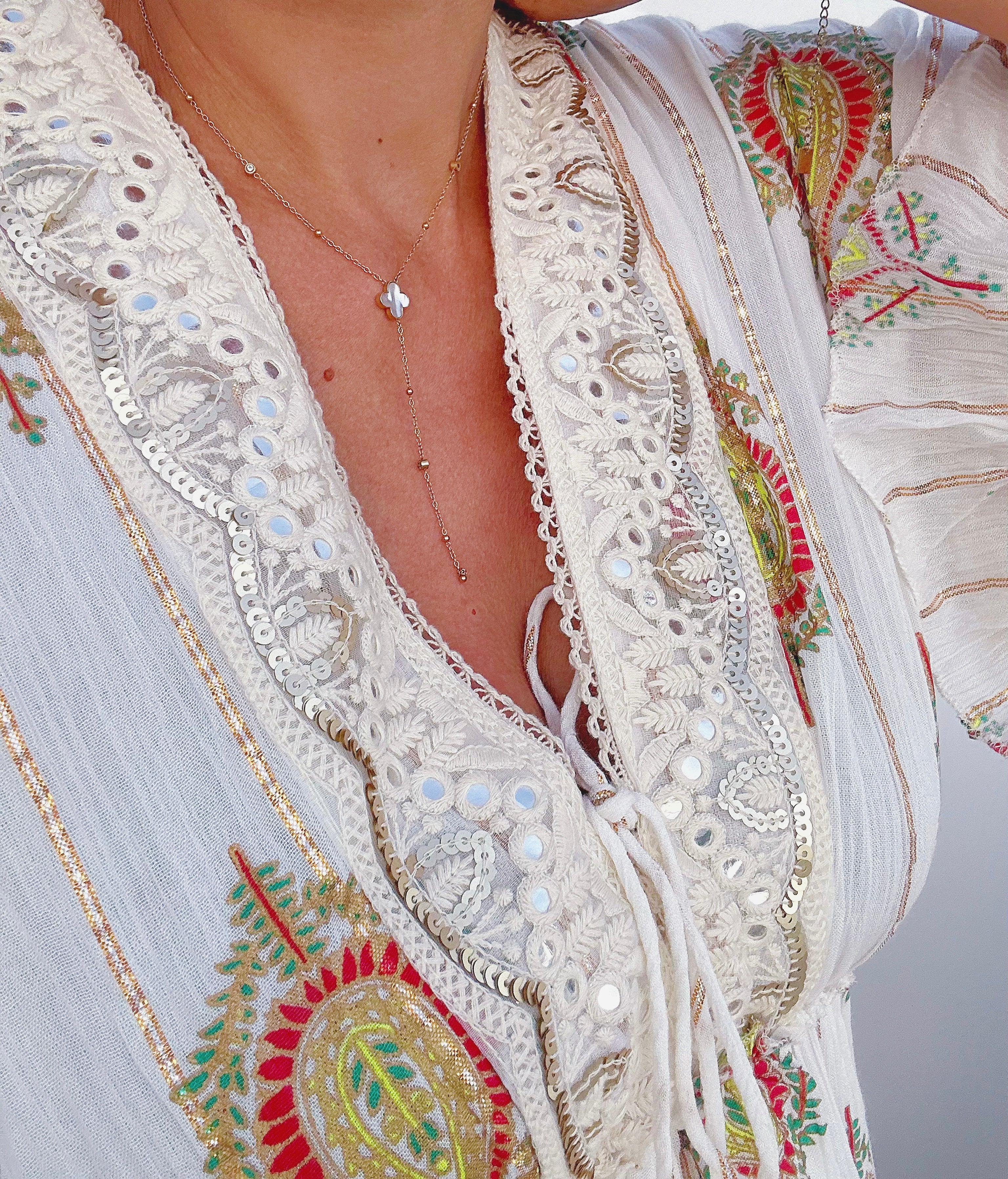 Collier Y Victoire en acier inoxydable doré trèfle nacre porté sur un décolleté