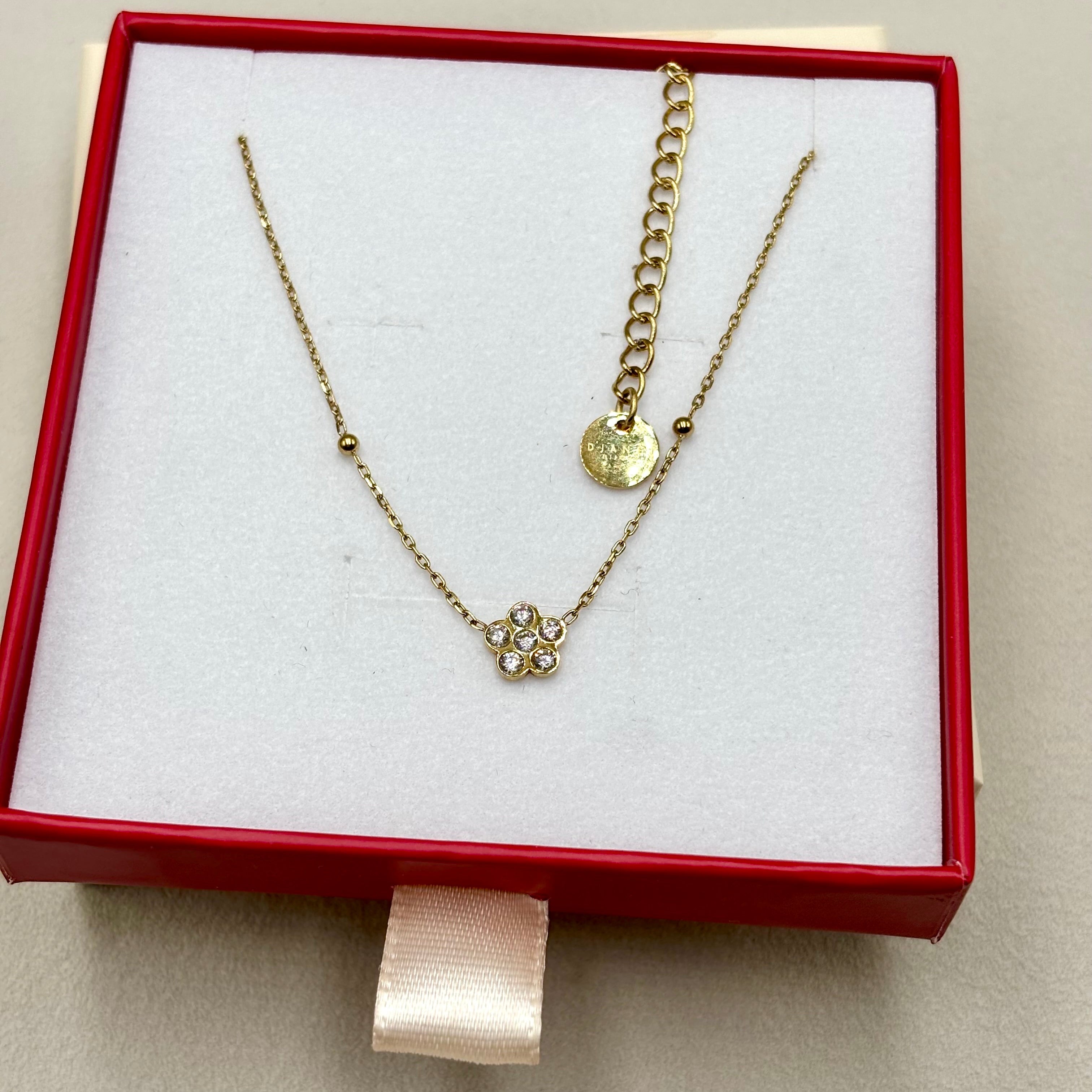 Collier fin en acier inoxydable doré à l'or fin orné d'une fleur en zirconium présenté dans une boite cadeau Djanet Bijoux