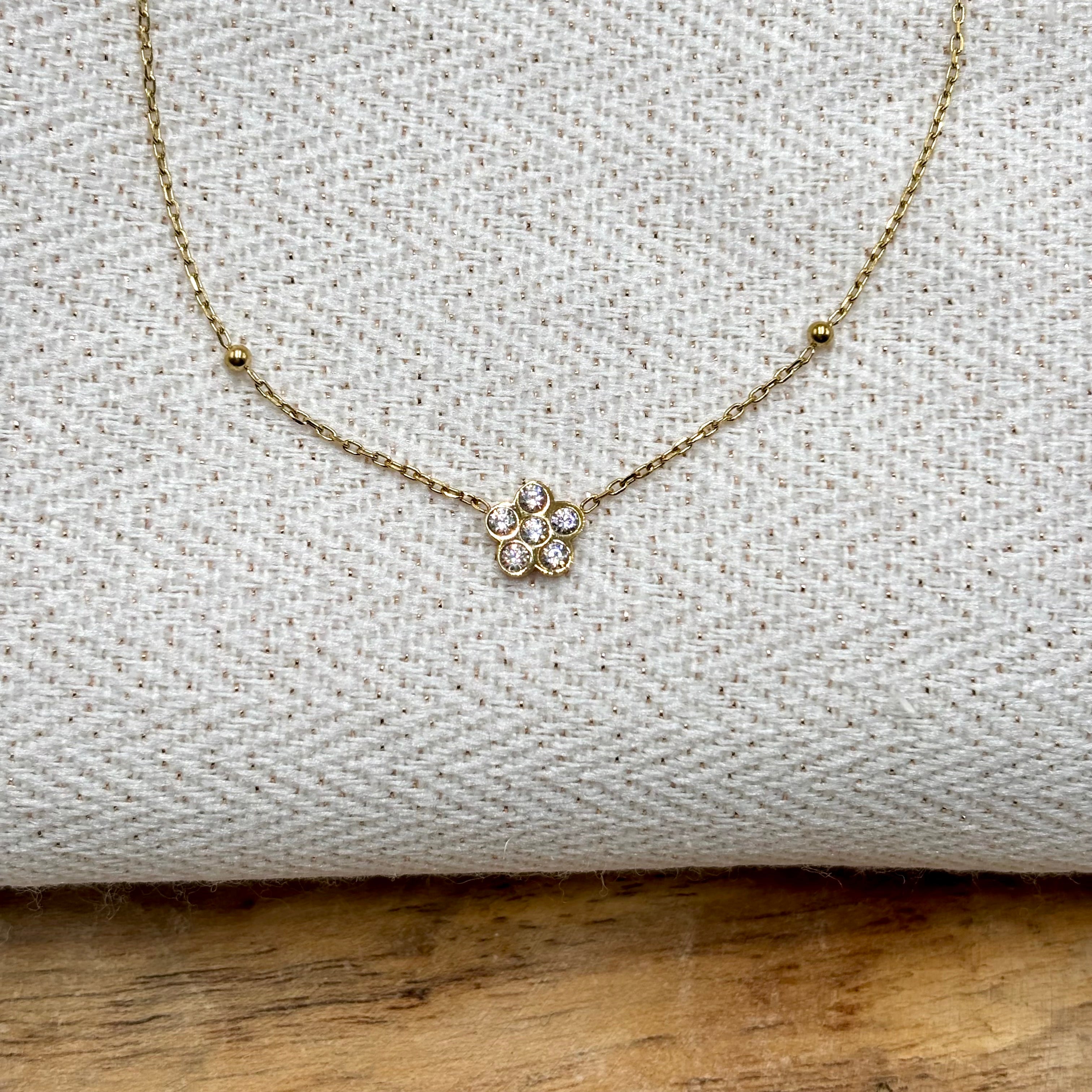 Collier fin acier inoxydable doré à l'or fin orné d'une fleur en zirconium entre deux billes dorées Djanet Bijoux