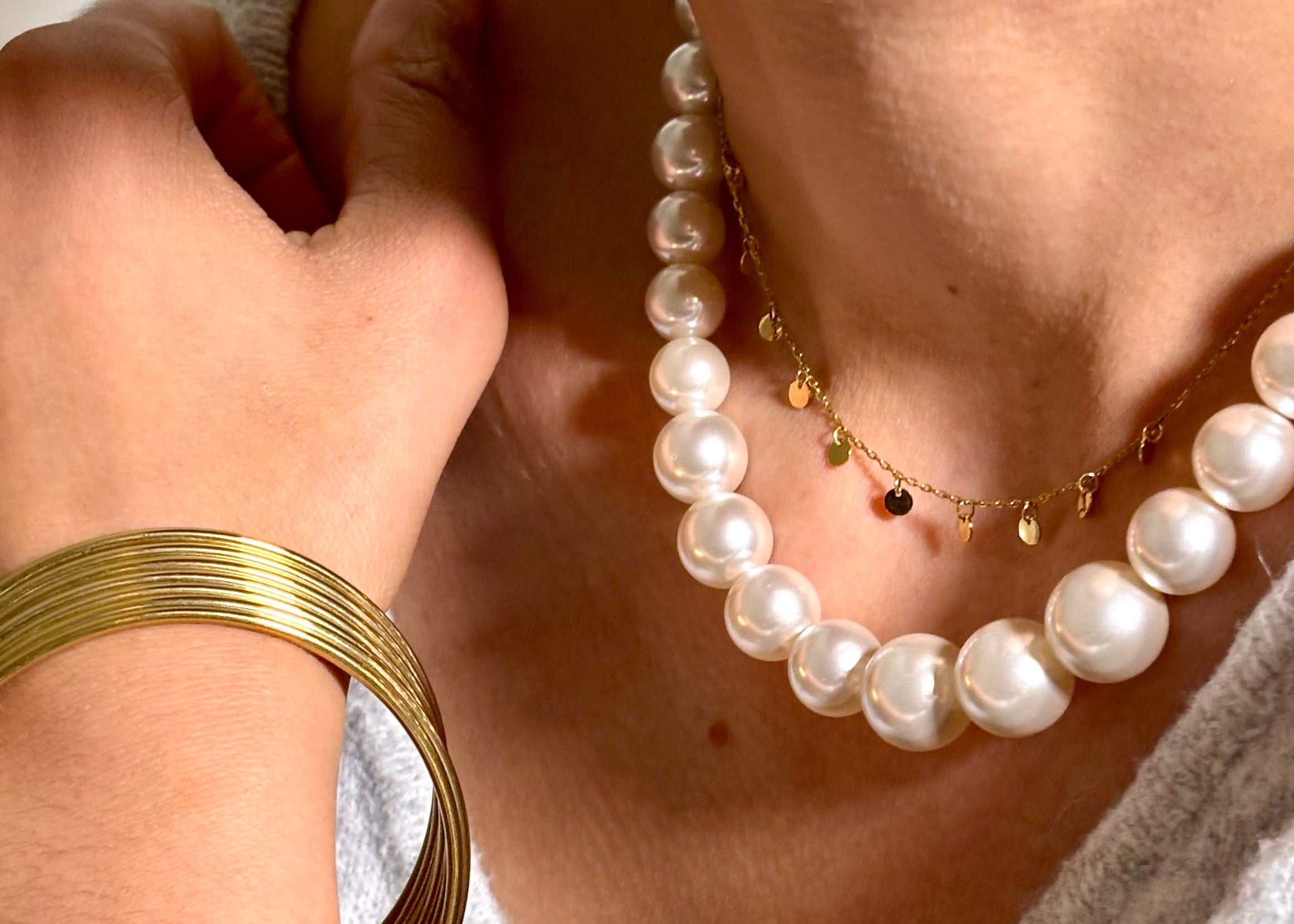 Collier grosses perles en resine blanche porté au cou avec collier petites confettis en acier doré Djanet Bijoux