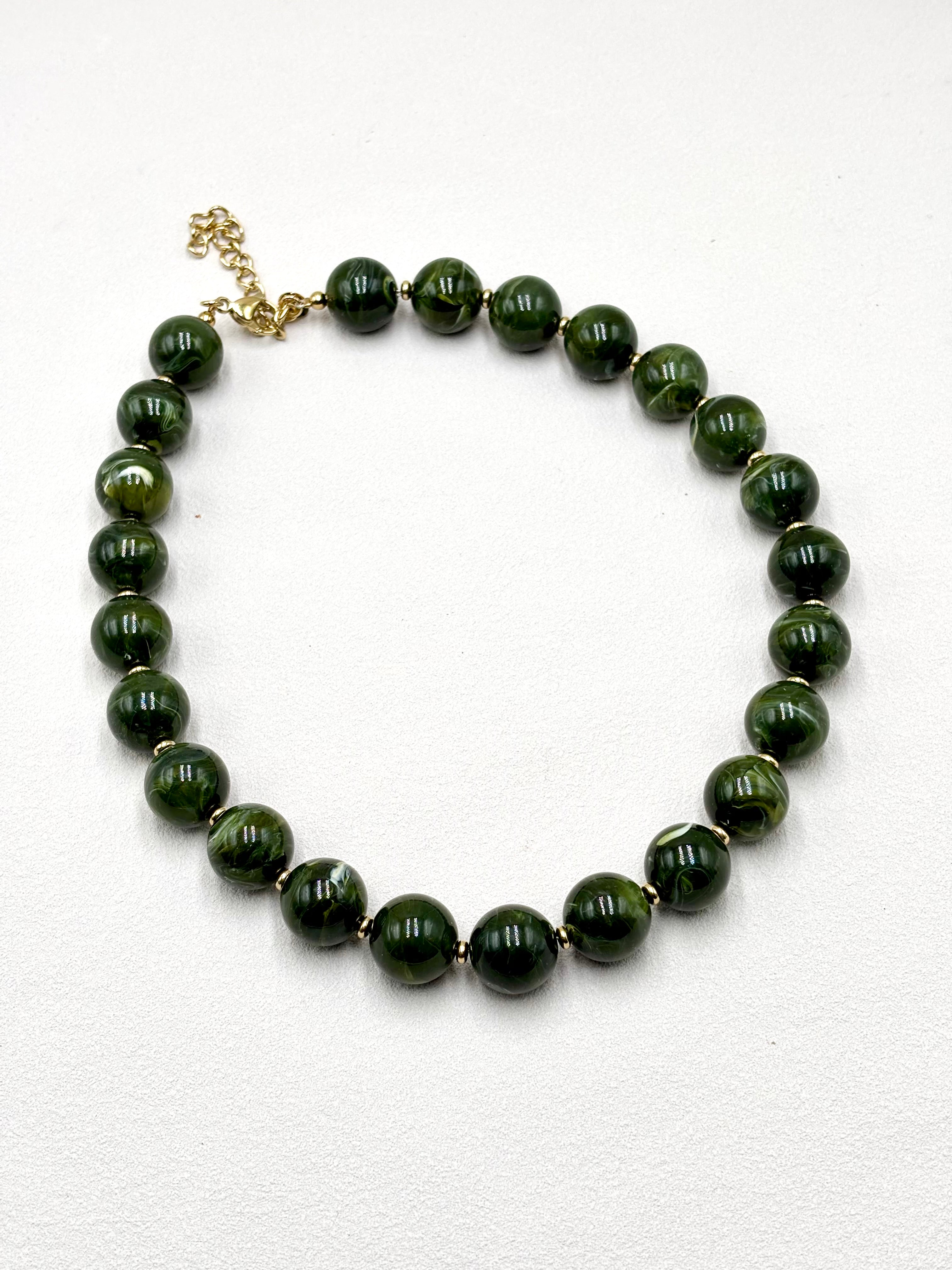 Collier grosses perles en résine rouge cerise et acier doré Perla sur fond blanc