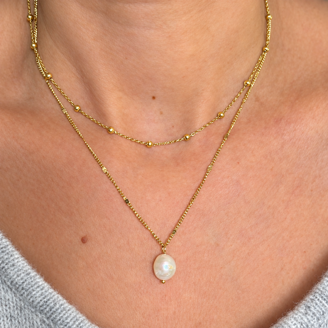 Collier en acier inoxydable doré avec pendentif perle d'eau douce porté avec un collier chaine boules