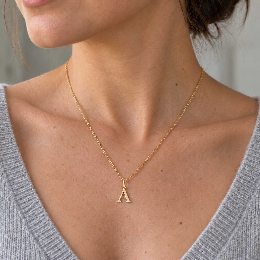 Collier initiale en acier inoxydable doré porté sur décolleté