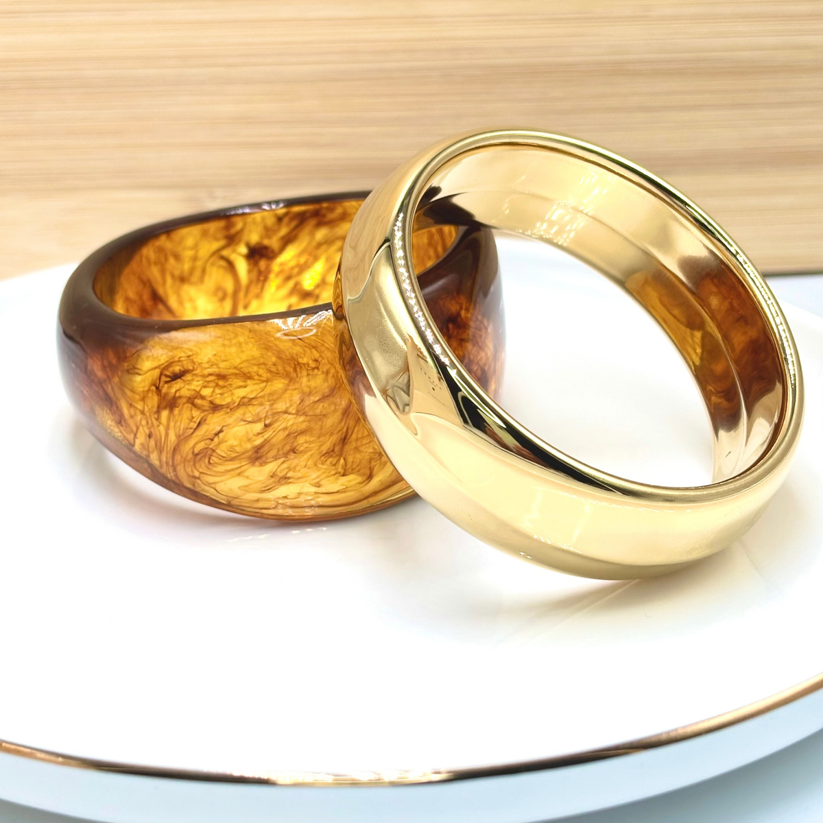 Deux Bracelets manchette en acier doré et en acétate brun large 