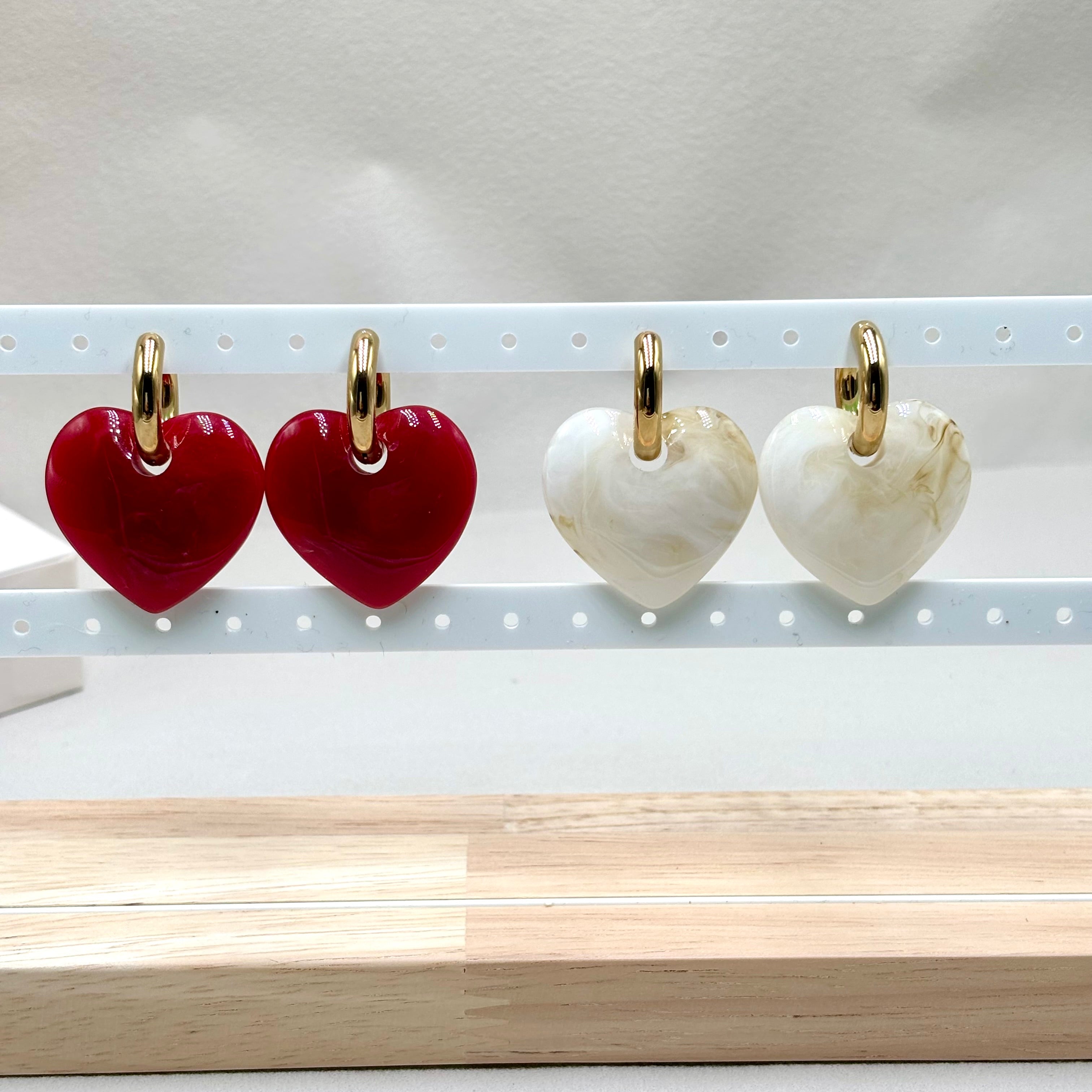 Deux paires de Boucles d Oreilles créoles acier inoxydable doré avec coeur en acetate doré rouge et doré Blanc Mika sur présentoir Djanet Bijoux