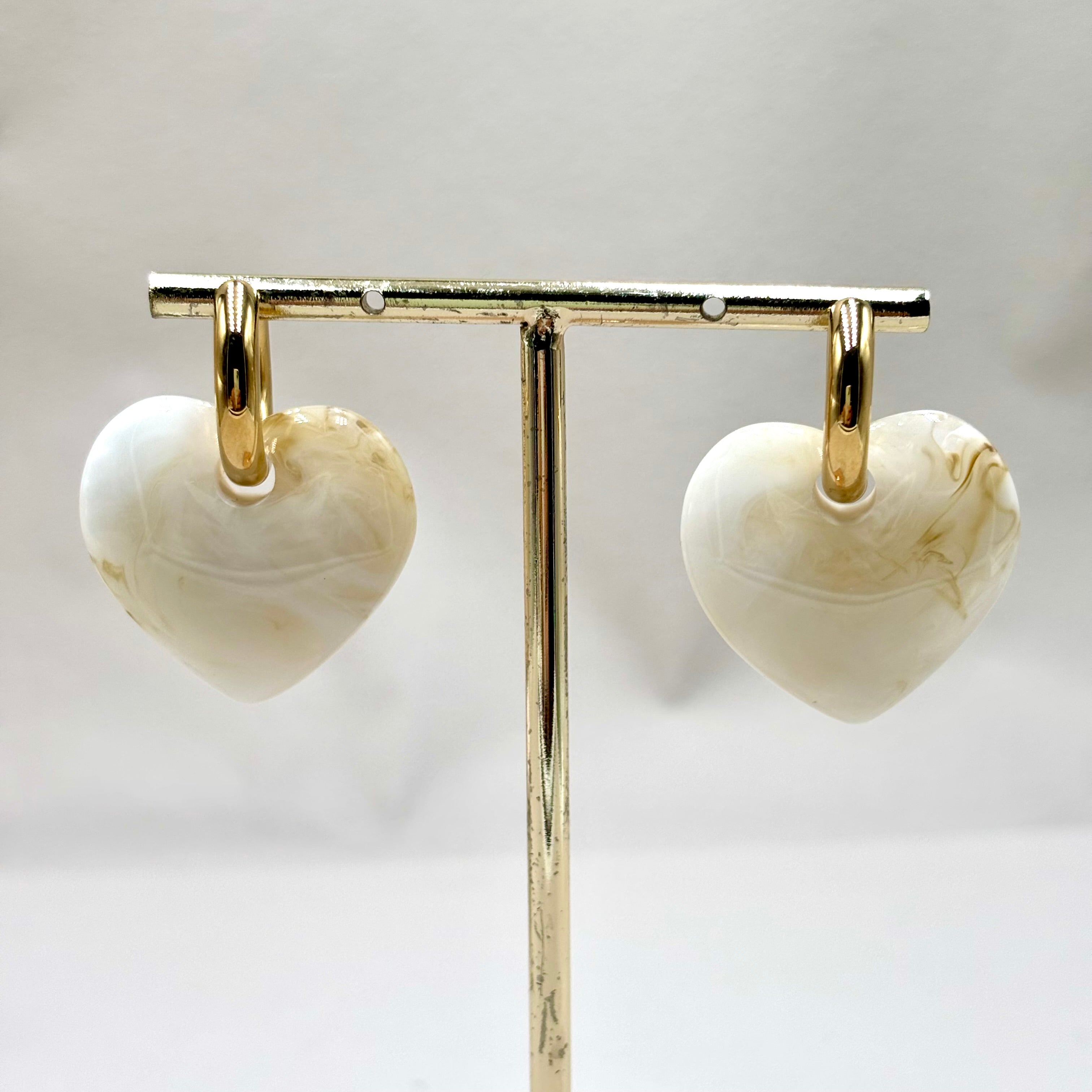 Boucles d'oreilles anneau en acier inoxydable dore et coeur en acétate blanc Djanet Bijoux sur présentoir