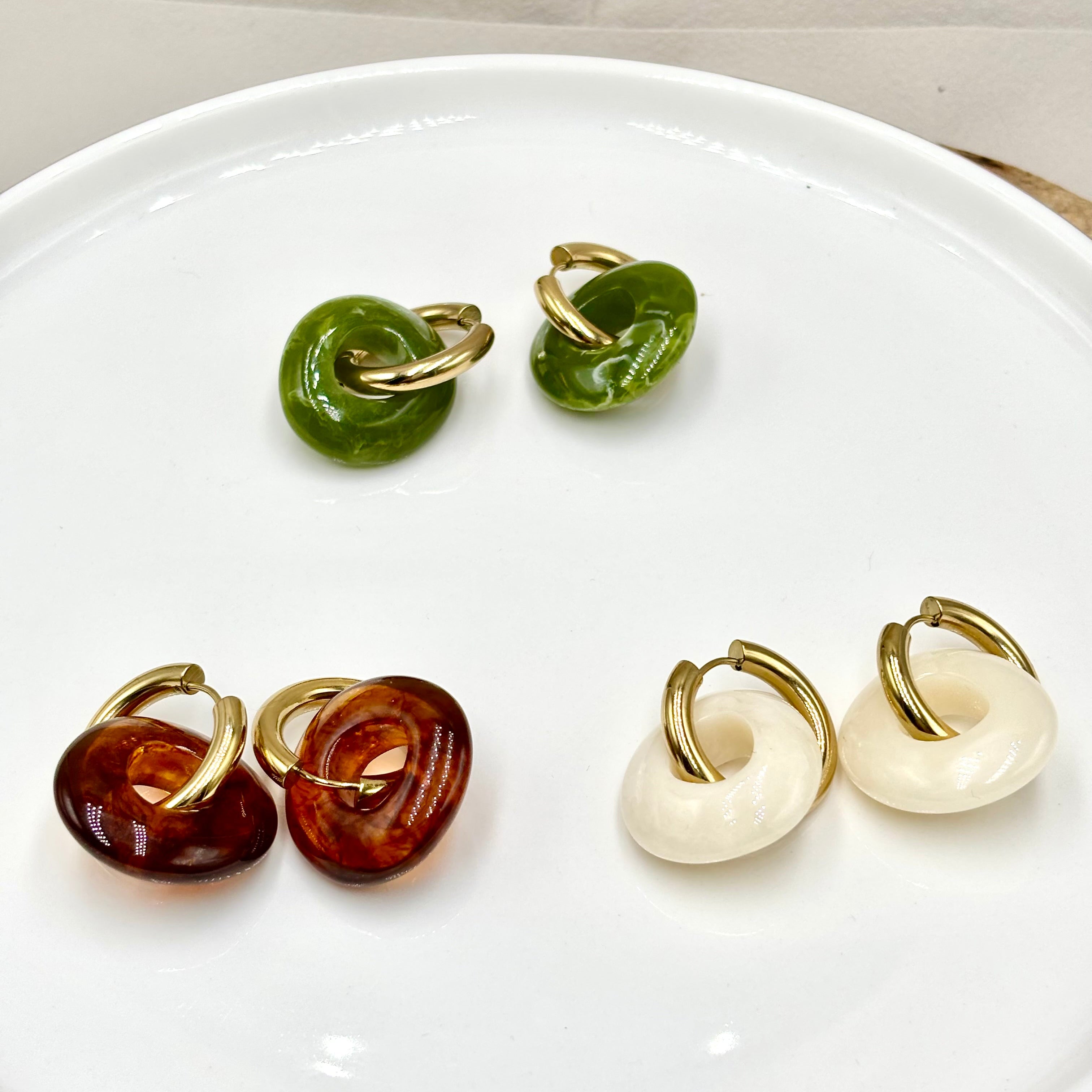 Boucles d'oreilles créoles en acier inoxydable doré et anneaux pendants en forme de donut en acétate coloré vert kaki, marron et blanc ivoire