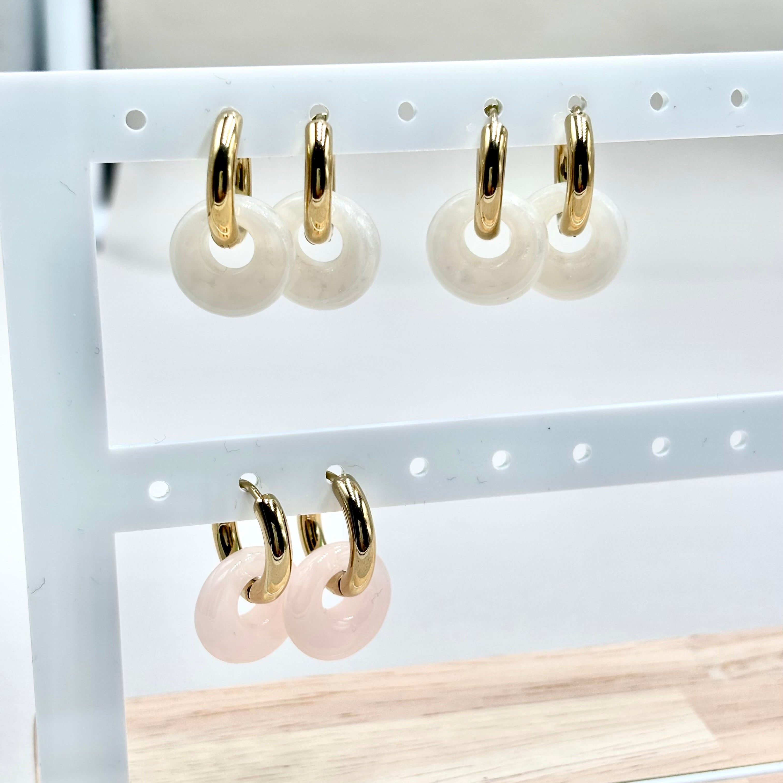 Boucles d'oreilles mini créoles en acier inoxydable doré en acétate blanc et rose sur présentoir