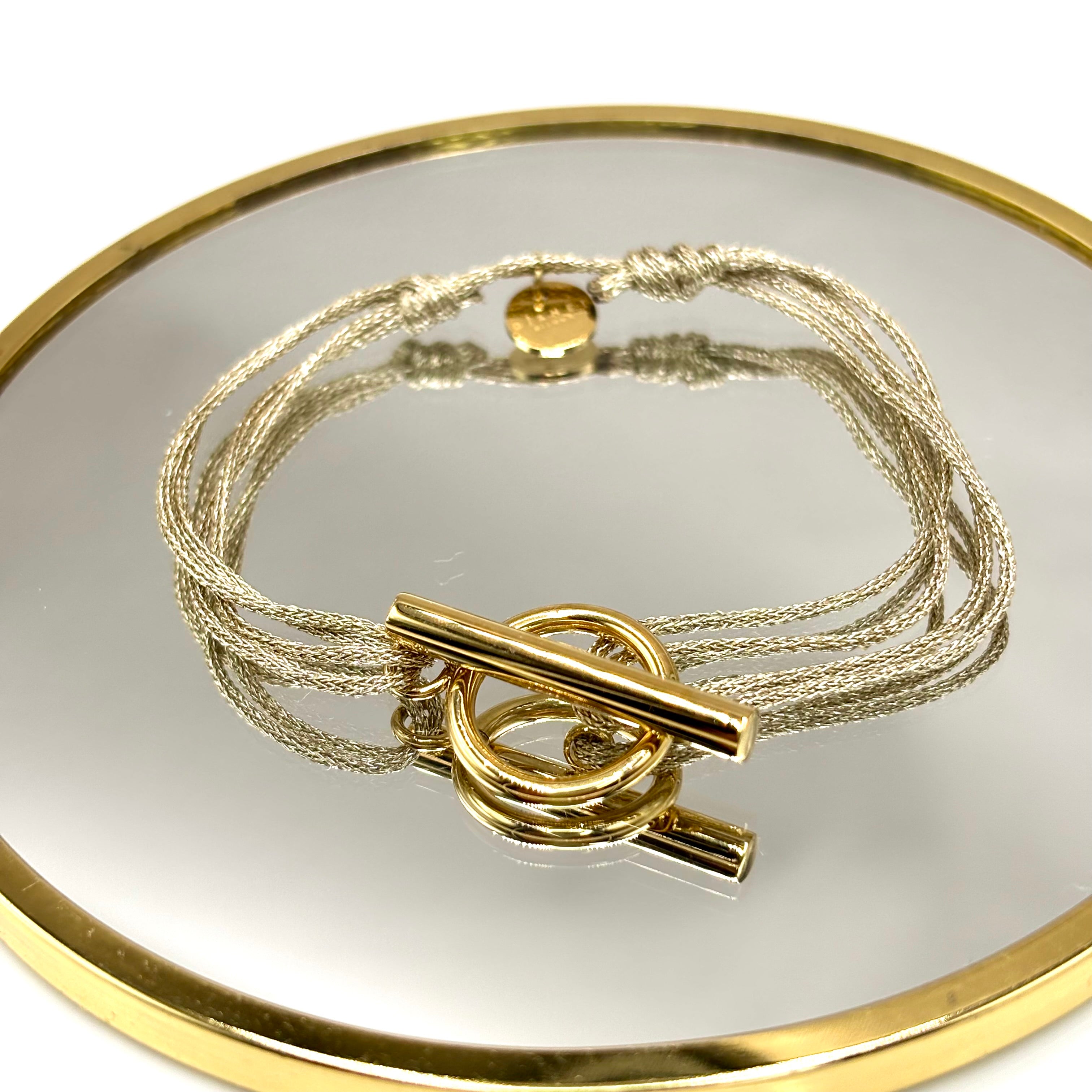 Bracelet cordon double doré scintillant fermoir T Toggle en acier inoxydable doré à l'or fin présenté sur miroir