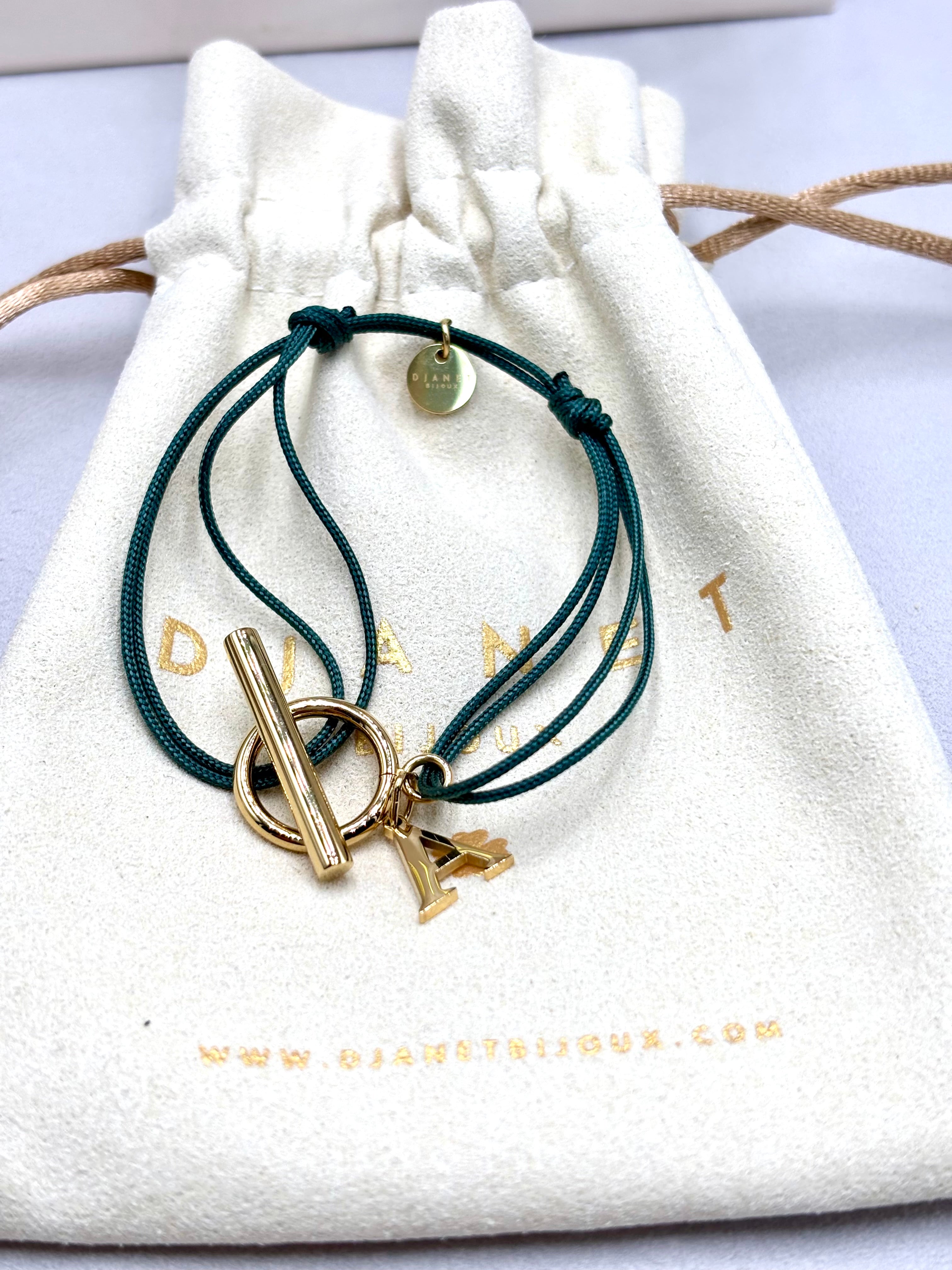 Bracelet double cordon vert  personnalise avec lettre initiale fermoir T Toggle en acier inoxydable dore présenté sur pochon Djanet Bijoux