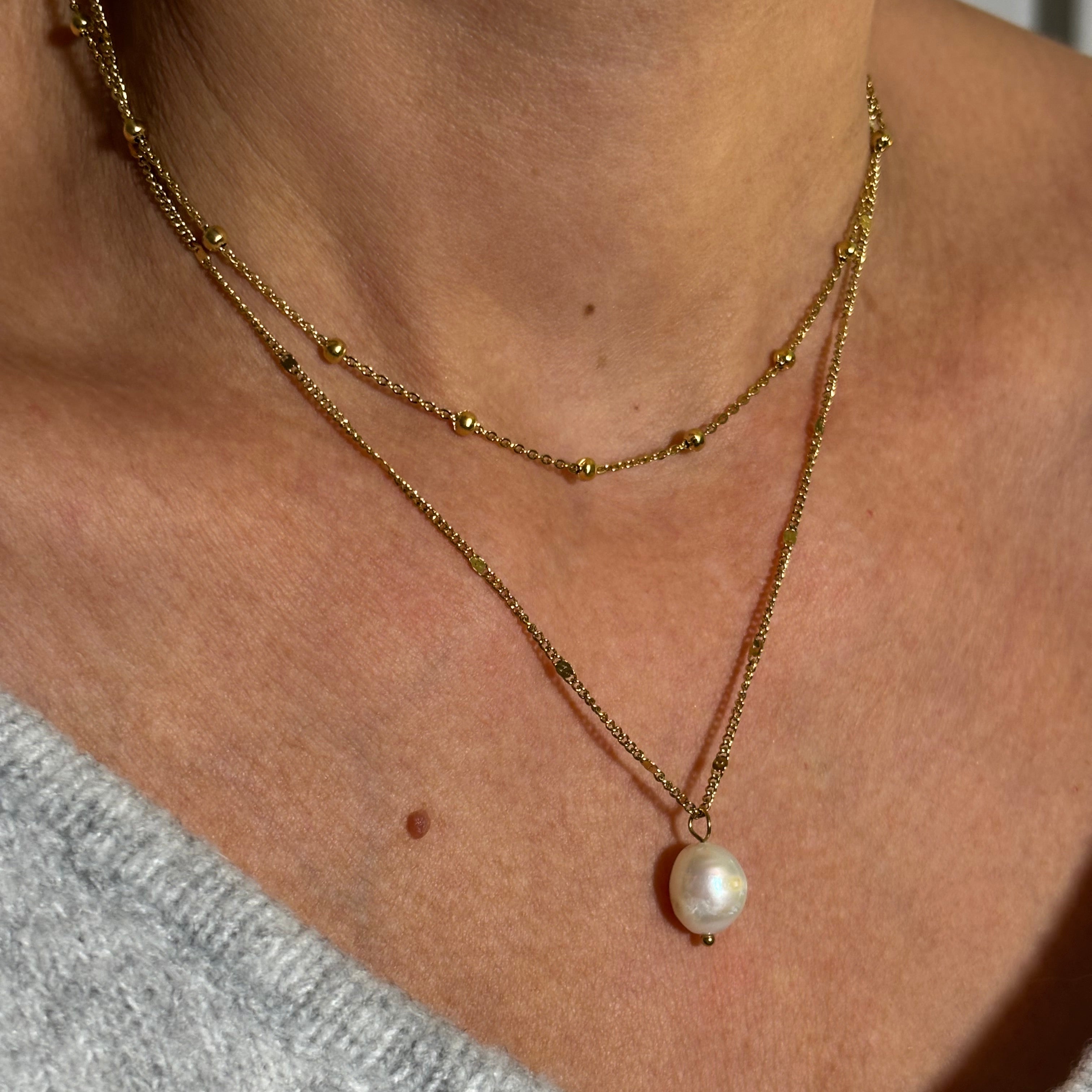 Collier chaine en acier doré avec pendentif perles d'eau douce porté avec chaîne boules