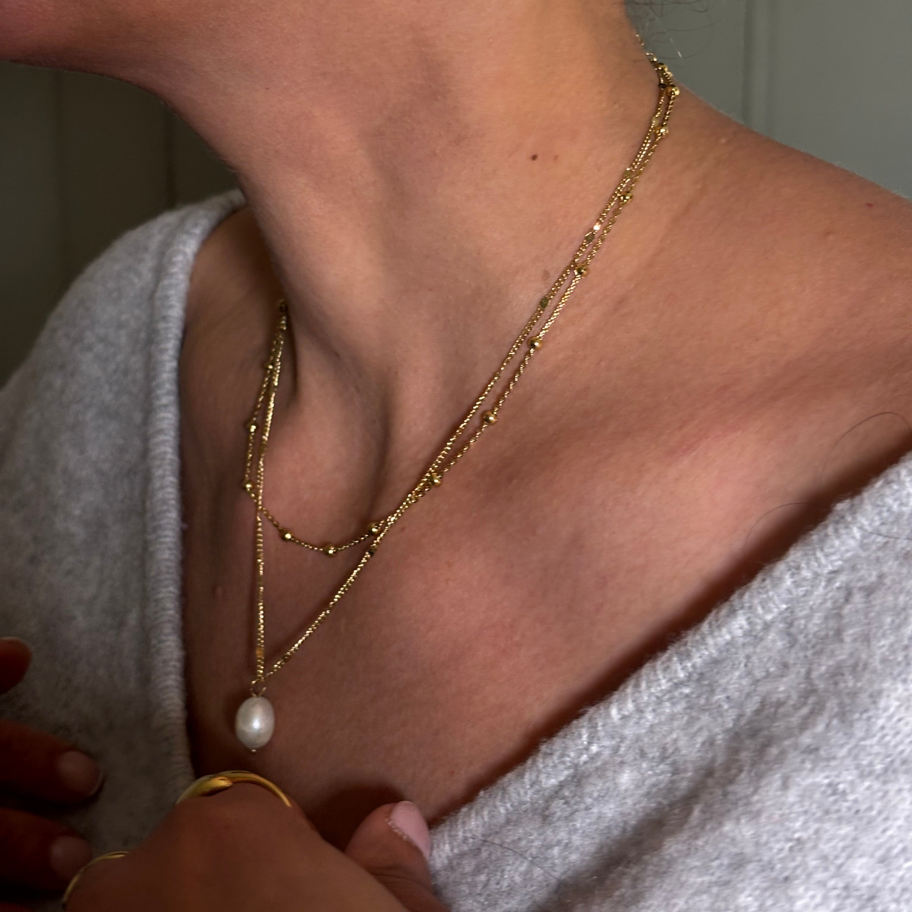 Collier chaine en acier doré avec pendentif perles d'eau douce porté avec chaîne boules