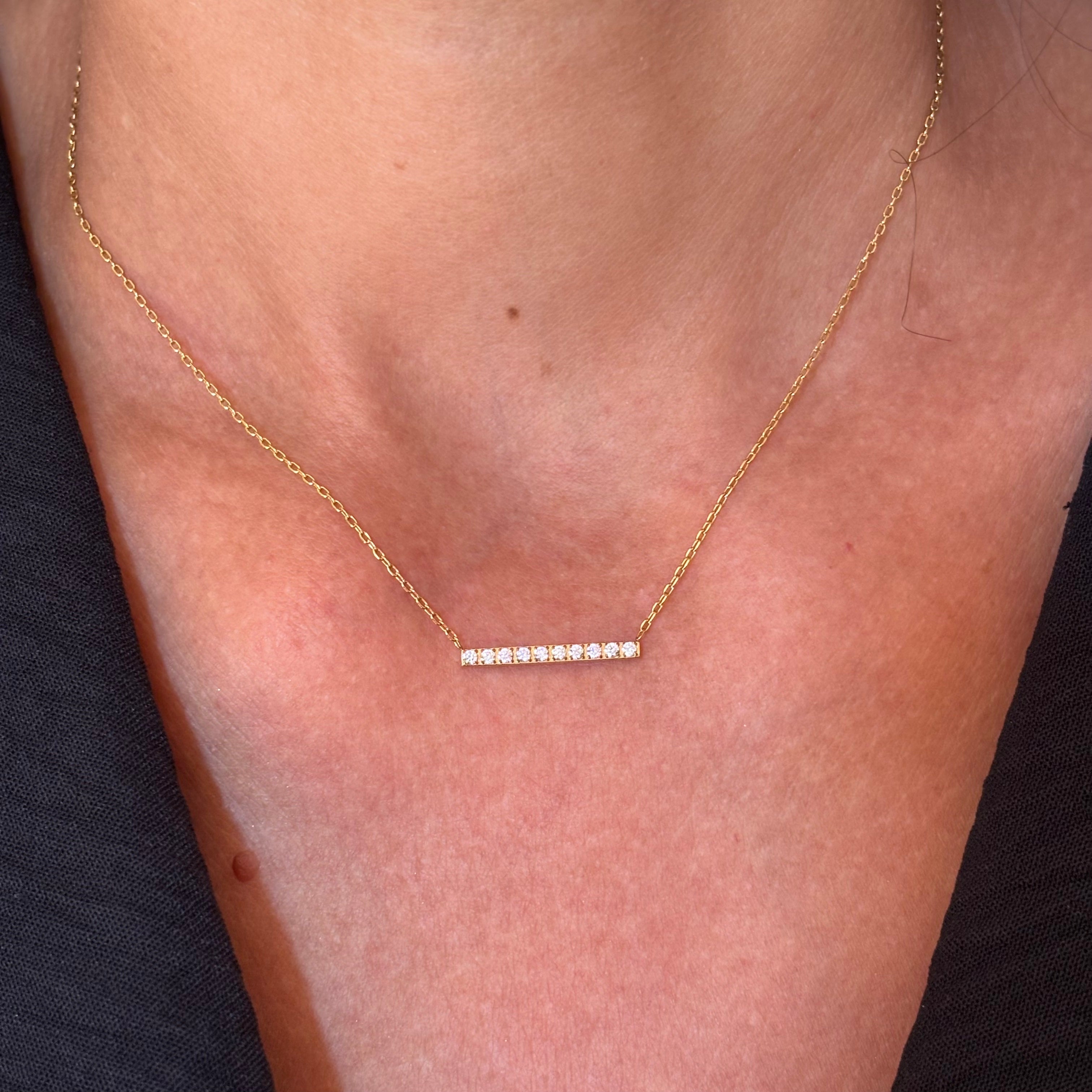 Collier chaine fine en acier inoxydable doré orné d'une barre horizontale sertie d'oxyde de zirconium