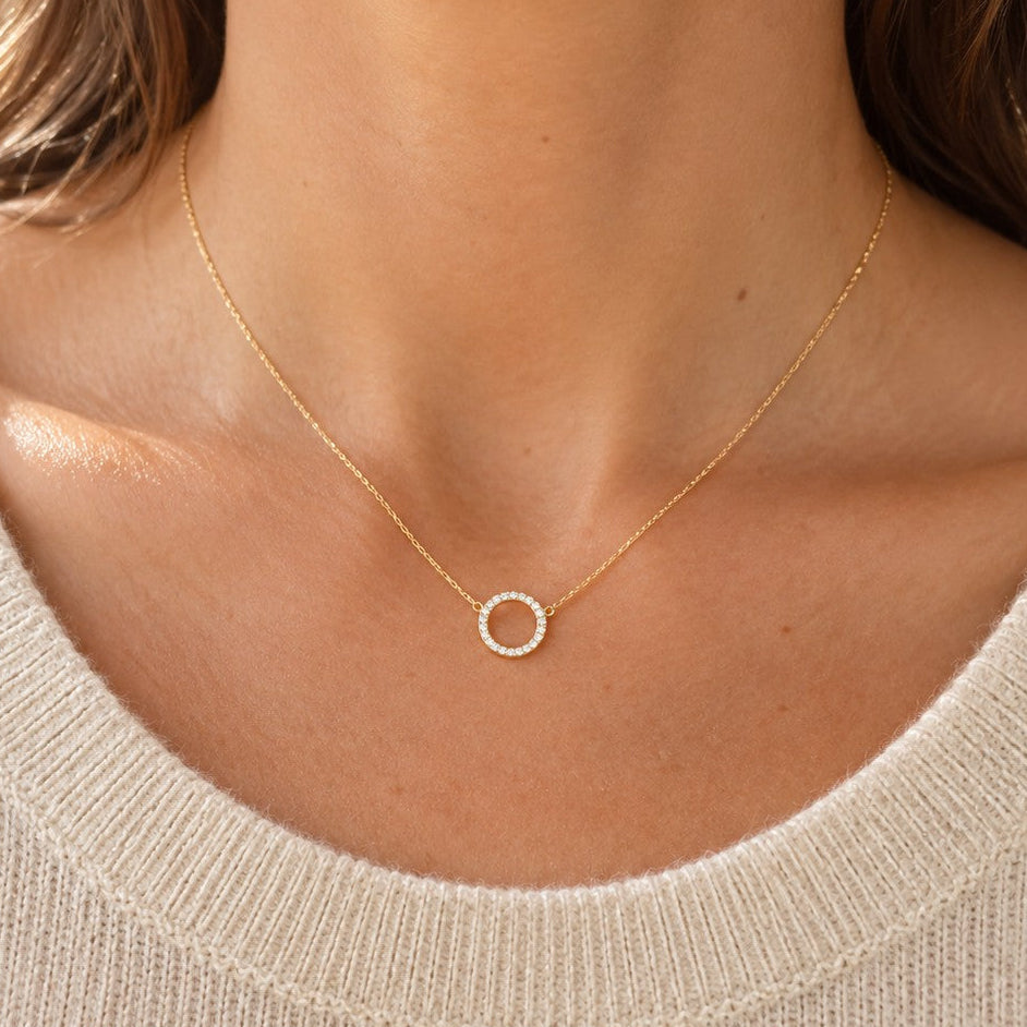 Collier doré cercle ajouré serti de zirconium porté sur décolleté 