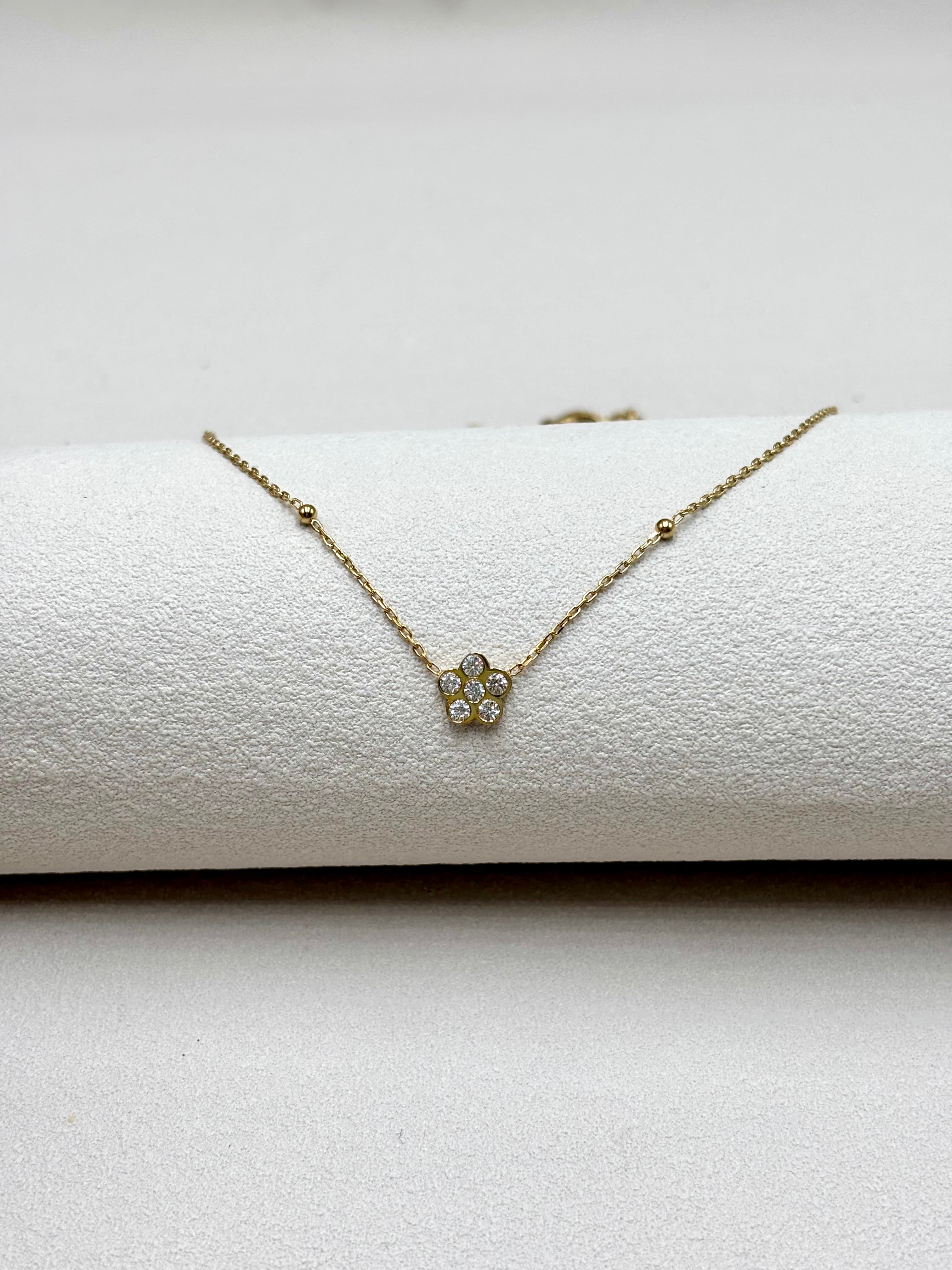 Collier fin orné d'une fleur en zirconium entre deux billes en acier doré Djanet Bijoux