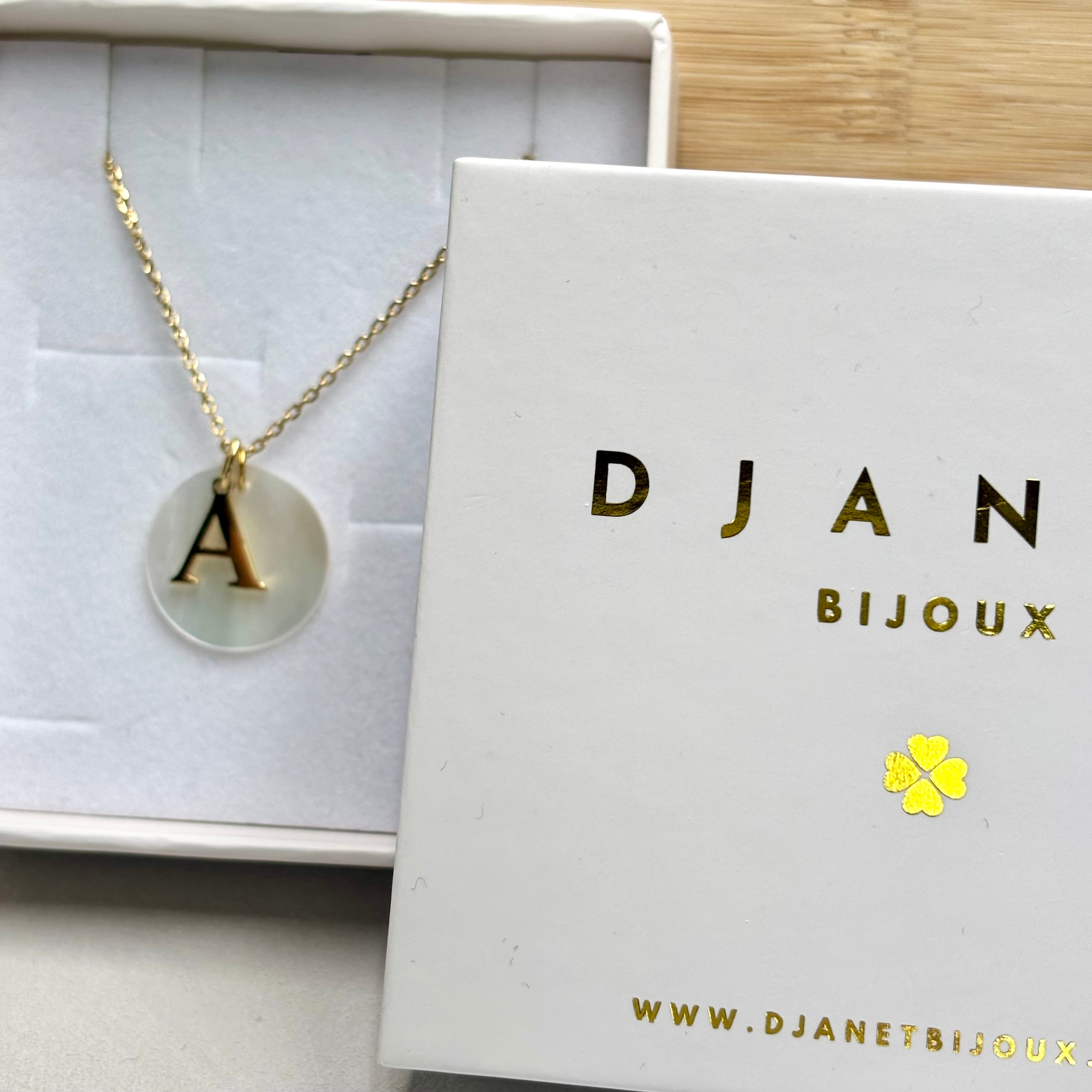 Collier personnalisé initiales prénom en acier inoxydable doré à l'or fin et médaille ronde nacrée sur chaine maille forçat présenté dans une boite cadeau Djanet Bijoux 