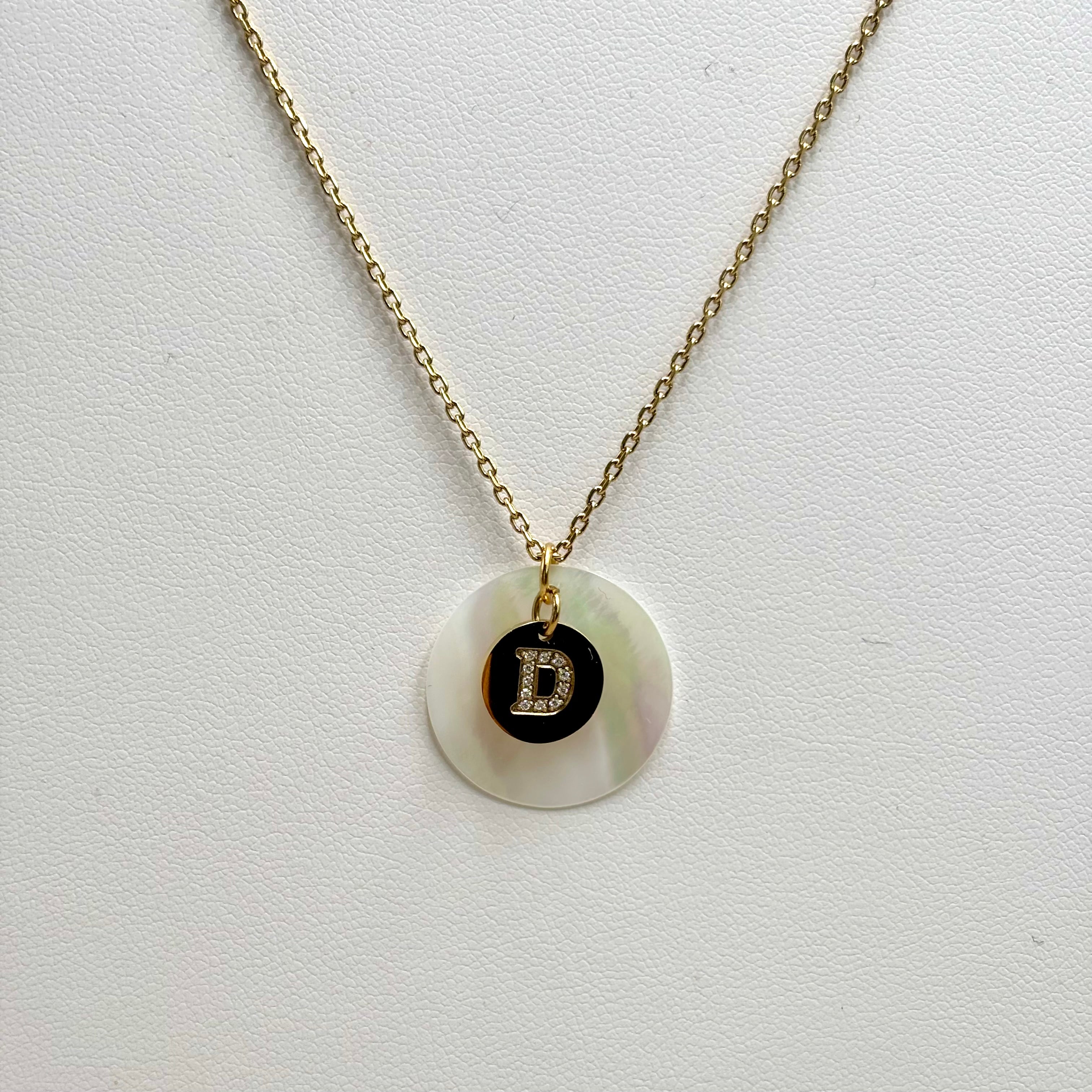 Collier personnalisé médaille nacrée et lettre zirconium gravé sur charm en acier doré sur fond blanc