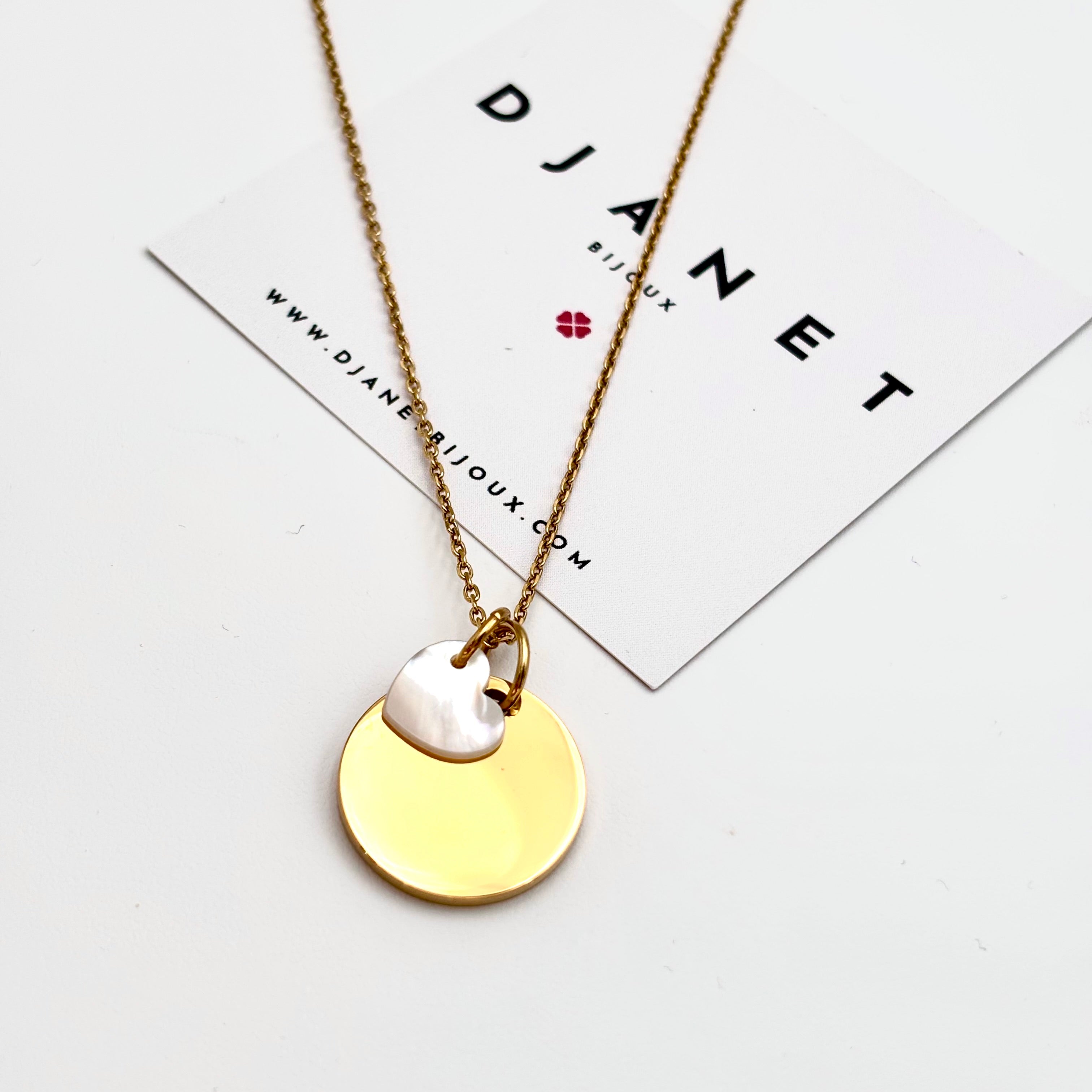 Collier personnalisé médaille à graver en acier doré et charm coeur en nacre sur chaine fine maille forçat présenté sur carte Djanet Bijoux