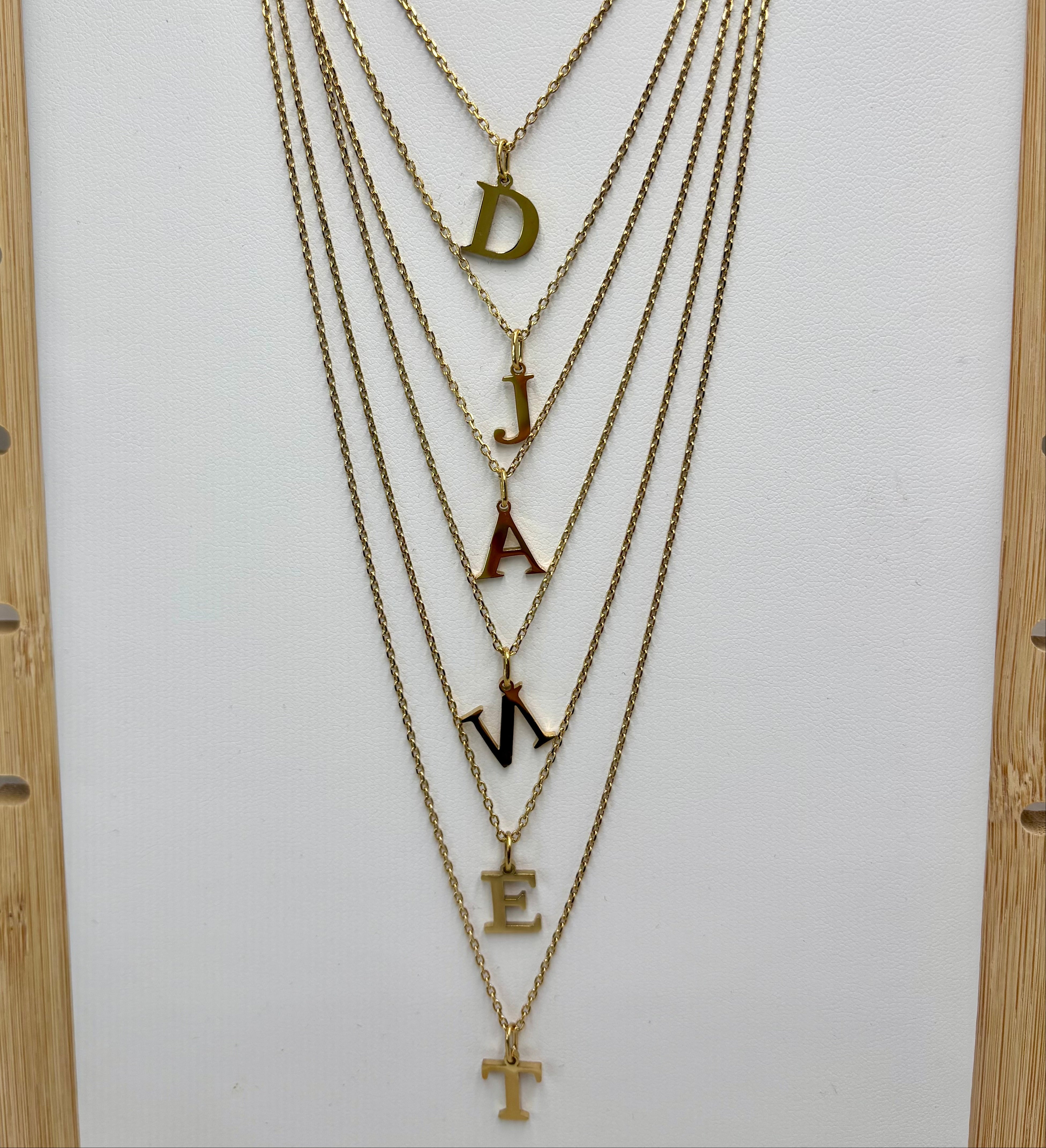 Colliers Personnalisés Initiales Djanet en acier 316L dore 14K sur présentoir à collier