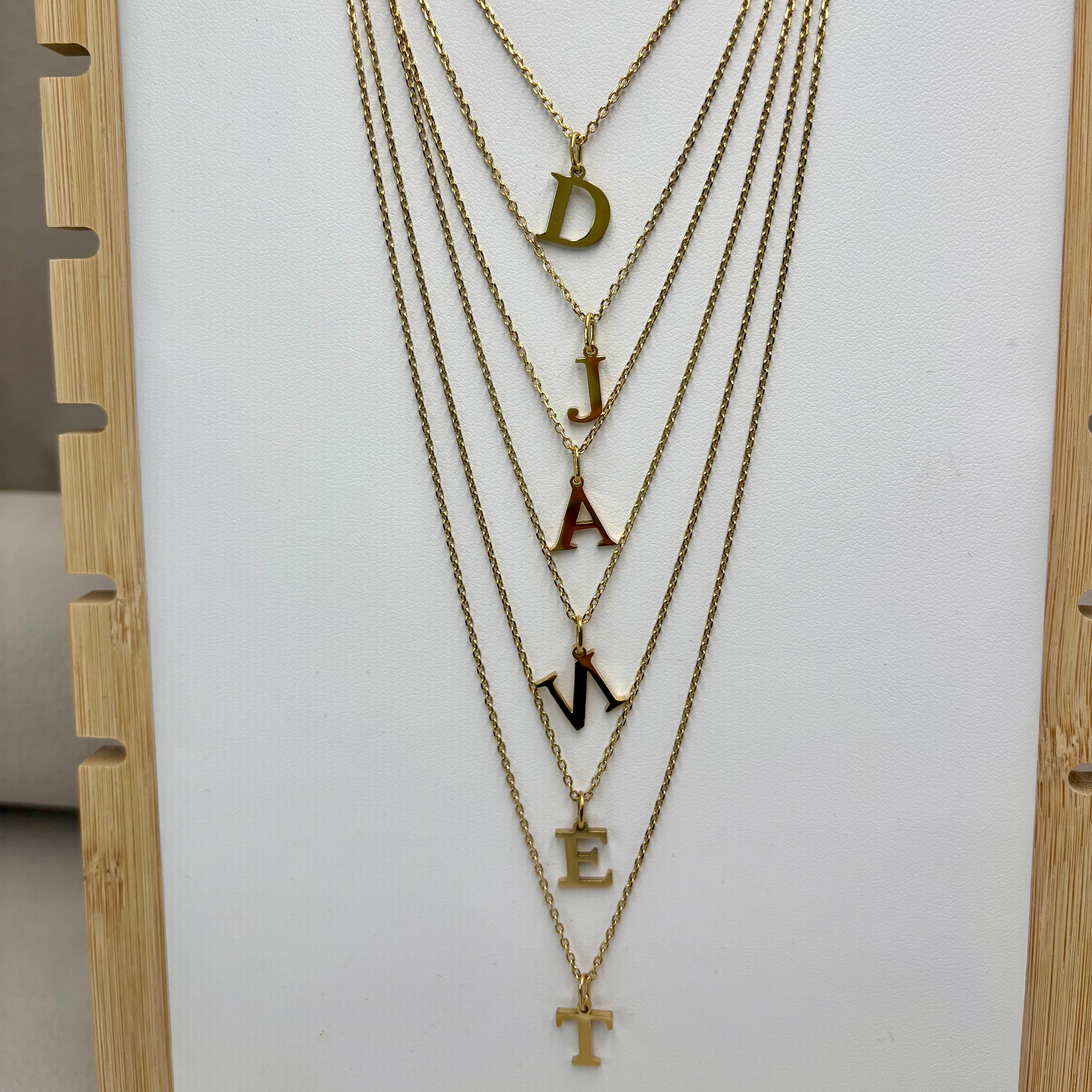 Colliers Personnalisés Initiales Djanet en acier 316L dore 14K sur présentoir à collier