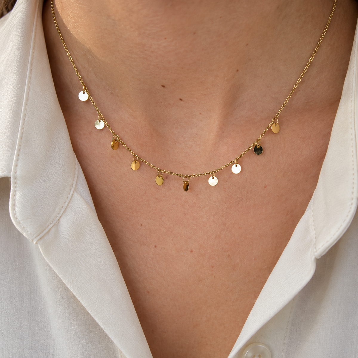 Collier confettis en acier inoxydable doré porté sur décolleté 